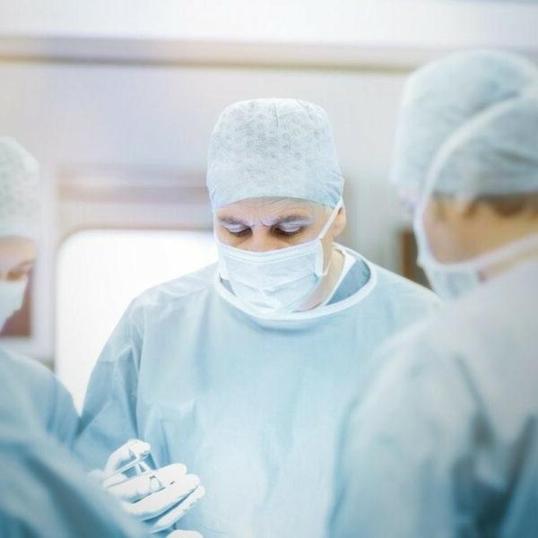 Doctors in gowns and face masks performing surgery